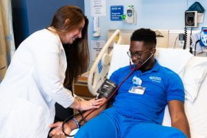 Nursing student checking blood pressure of another nursing student