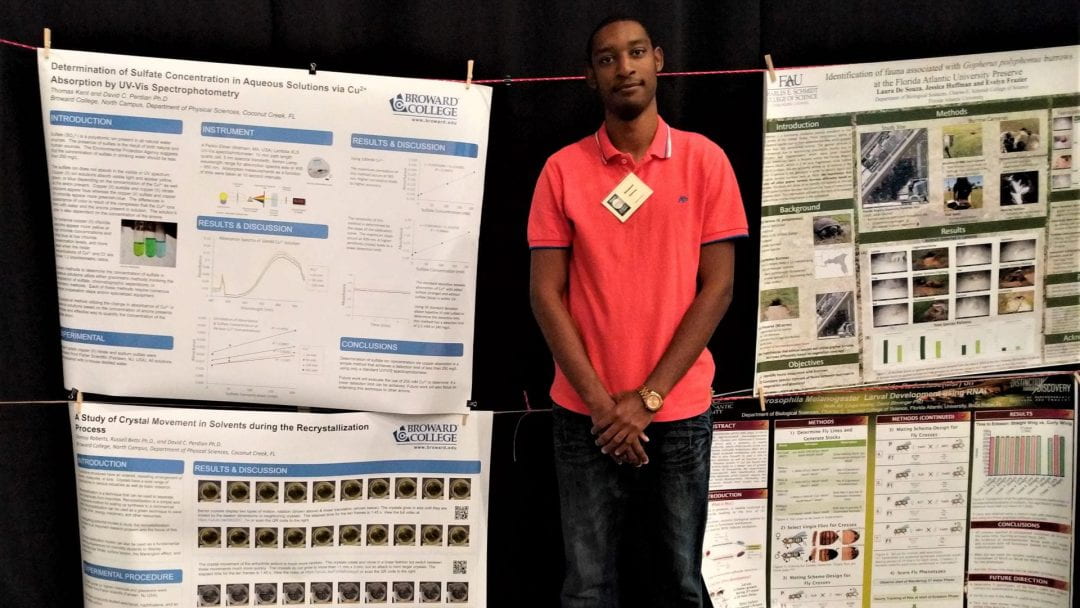 Damoy Roberts standing in front of his research poster